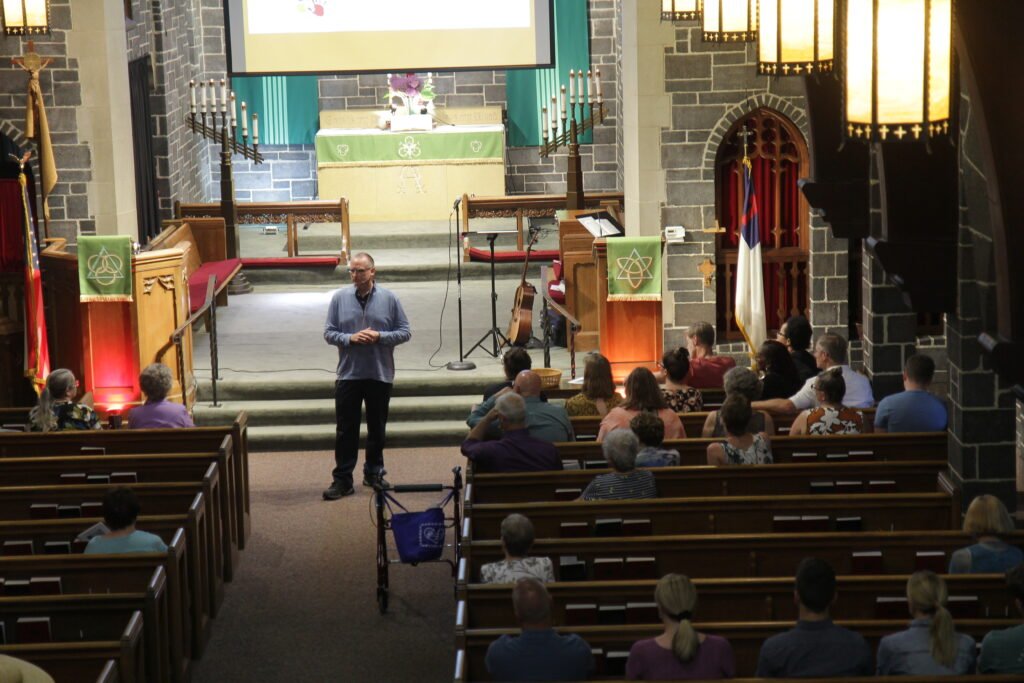 Dr. Scott Gostchock presenting in front of a church in Minneapolis, Minnesota.