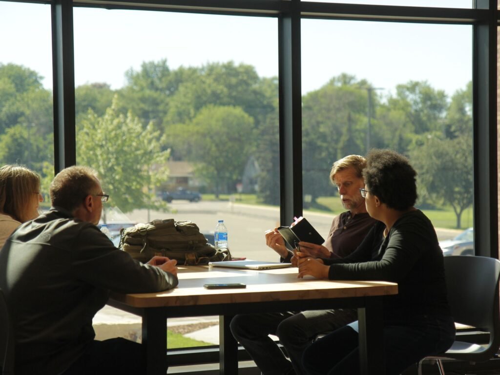 A group of people sitting at a table. Mentorship is more than just what's formal. It's also conversations like this.