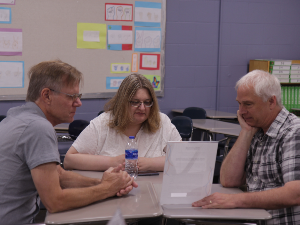 A picture of educators sitting at desks to talk about discussion topics