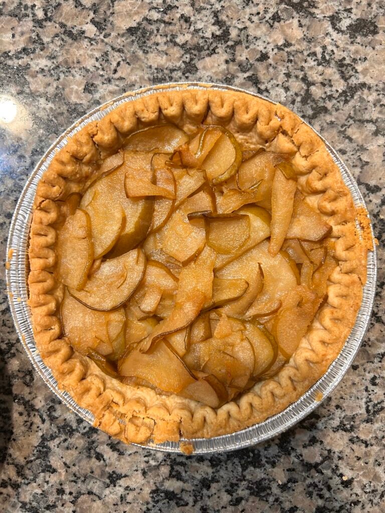 A pear pie sits on a countertop.