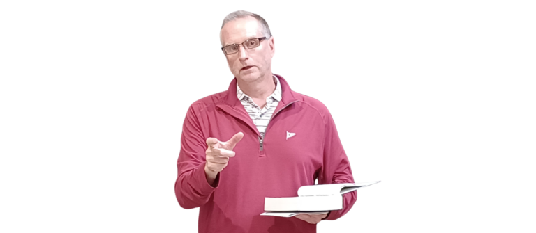 An image of Dr. Scott Gostchock presenting while holding a Bible